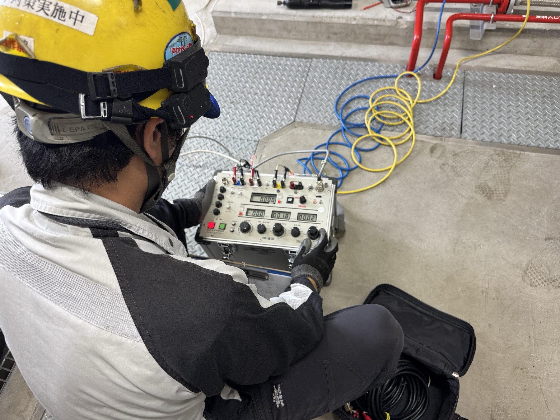 測定機器で電気設備を点検する作業員
